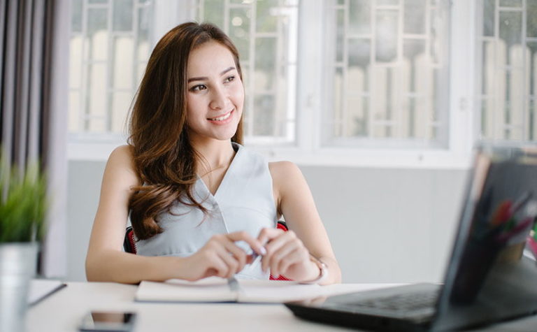 Femme réalisant sa déclaration de changement d’adresse en ligne sur son ordinateur portable