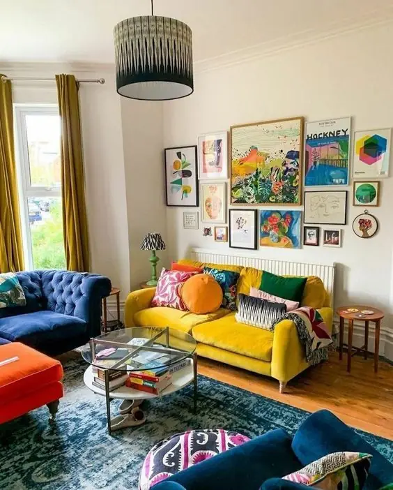 Photo d'un séjour, avec deux canapés, un jaune poussin et un bleu nuit et une décoration sobre mais coloré ou se mélange vintage et modernité