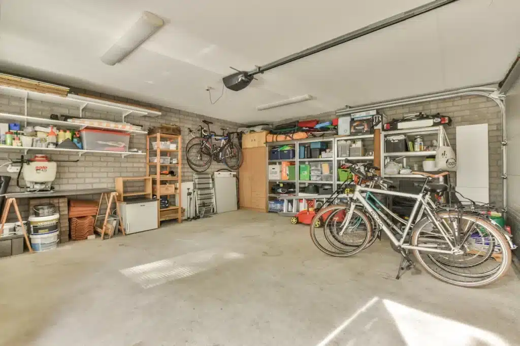 Garage rangé avec vélo, étagères murales et rangements au sol