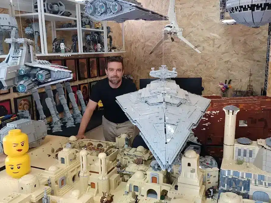 Construction en LEGO sur le thème de Star Wars, avec un homme qui prend la pose pour la photo. 