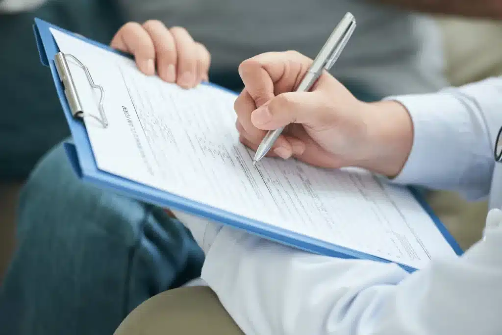 Personne entrain de remplir un formulaire de demande de stationnement pour un déménagement.Calpin avec formulaire papier et stylo.