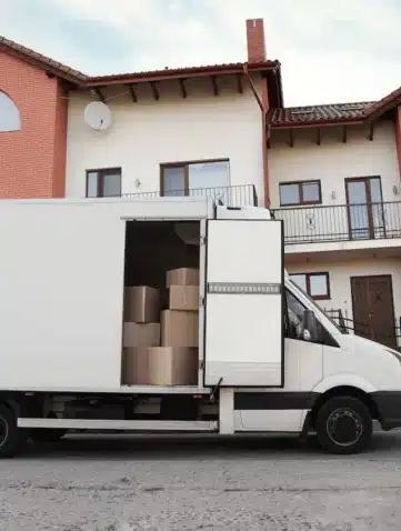 Camion de déménagement stationné sur voirie devant des maisons