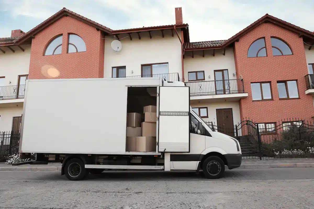 Camion de déménagement stationné sur voirie devant des maisons