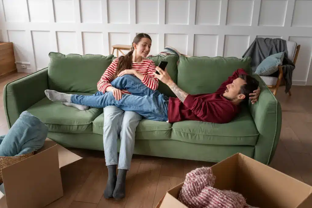 Jeune couple installé dans un canapé dans un appartement