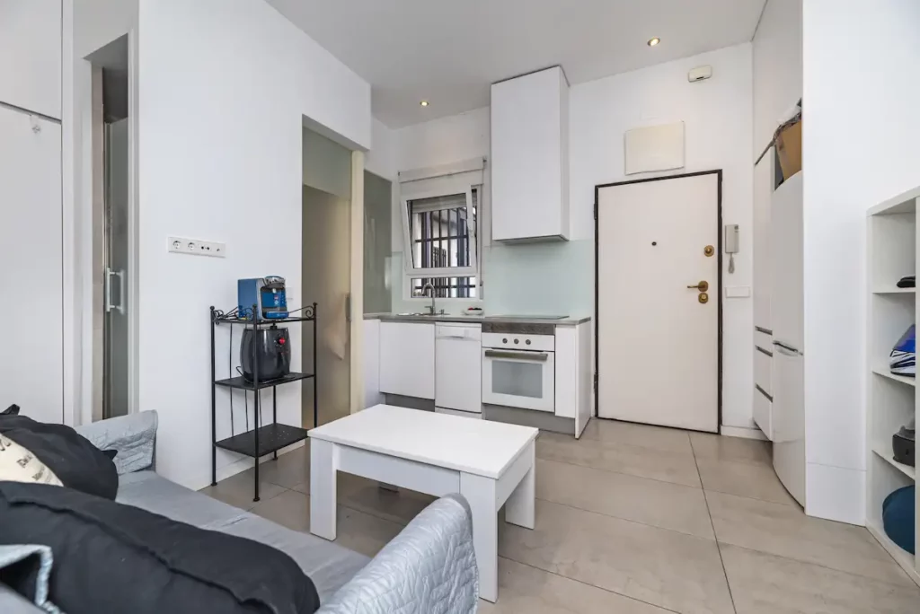 Photo d'un appartement style studio, avec un canapé une cuisine ouverte et une table basse. 