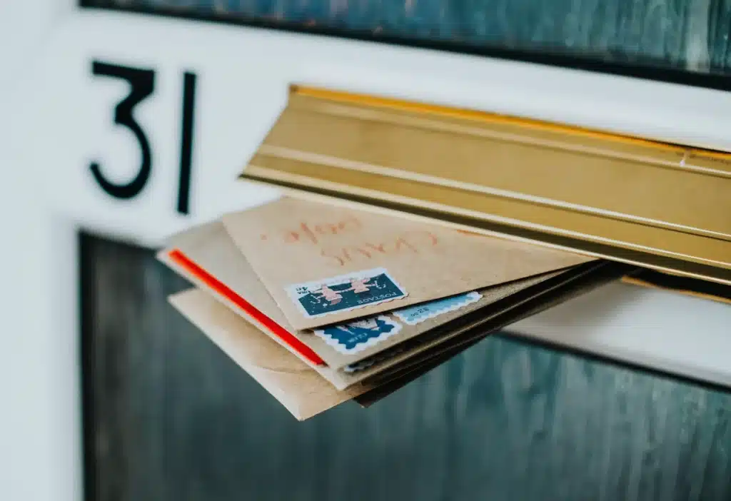 Courriers sortant d'une boîte aux lettres.