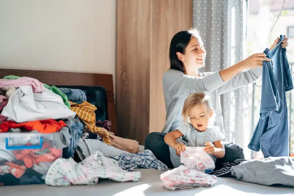 Une mère et sa fille qui trient le linge sur le lit. 