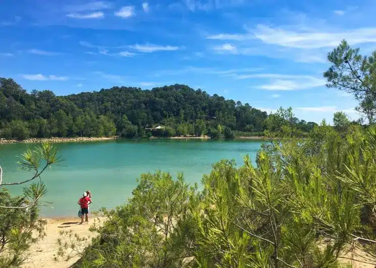Photo du lac de Cécélès à l'eau turquoise et au magnifiques pins qui entourent le lac.