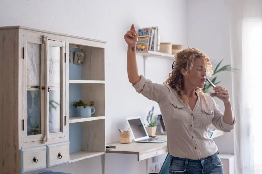 femme qui chante dans son salon entrain de faire le ménage pour son tri de printemps 