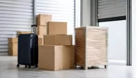 Valise et cartons entreposés dans un box de stockage avant un déménagement à l’étranger