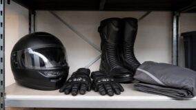 Casque, gants, bottes et blouson de moto rangés sur une étagère