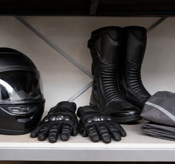 Casque, gants, bottes et blouson de moto rangés sur une étagère