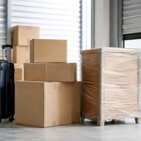 Valise et cartons déposés à l’entrée d’un box de stockage pendant une mutation professionnelle